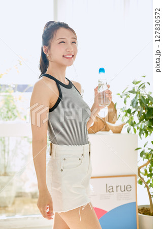 部屋ででラムネを楽しむ夏の爽やかな若い女性の笑顔 部屋ででラムネを楽しむ夏の爽やかな若い女性の笑顔 127830572