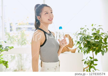 部屋ででラムネを楽しむ夏の爽やかな若い女性の笑顔 127830574