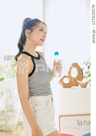 部屋ででラムネを楽しむ夏の爽やかな若い女性の笑顔 部屋ででラムネを楽しむ夏の爽やかな若い女性の笑顔 127830576