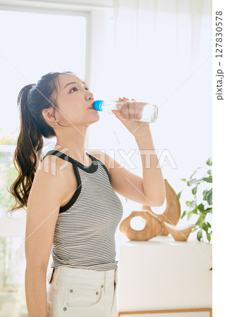 部屋ででラムネを楽しむ夏の爽やかな若い女性の笑顔 127830578