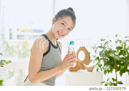 部屋ででラムネを楽しむ夏の爽やかな若い女性の笑顔 127830579