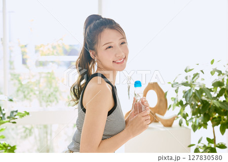 部屋ででラムネを楽しむ夏の爽やかな若い女性の笑顔 部屋ででラムネを楽しむ夏の爽やかな若い女性の笑顔 127830580