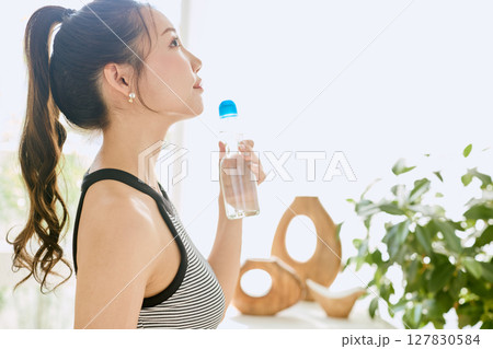 部屋ででラムネを楽しむ夏の爽やかな若い女性の笑顔 127830584