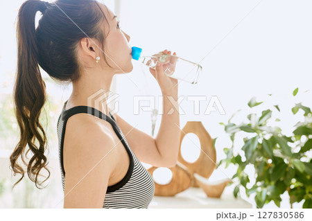 部屋ででラムネを楽しむ夏の爽やかな若い女性の笑顔 127830586