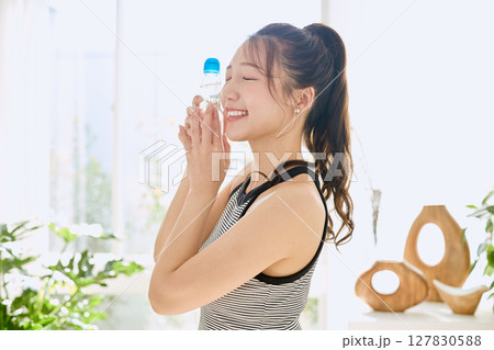 部屋ででラムネを楽しむ夏の爽やかな若い女性の笑顔 部屋ででラムネを楽しむ夏の爽やかな若い女性の笑顔 127830588