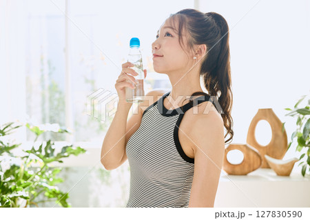 部屋ででラムネを楽しむ夏の爽やかな若い女性の笑顔 部屋ででラムネを楽しむ夏の爽やかな若い女性の笑顔 127830590