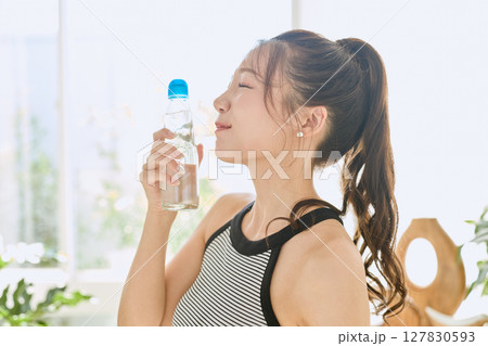 部屋ででラムネを楽しむ夏の爽やかな若い女性の笑顔 部屋ででラムネを楽しむ夏の爽やかな若い女性の笑顔 127830593