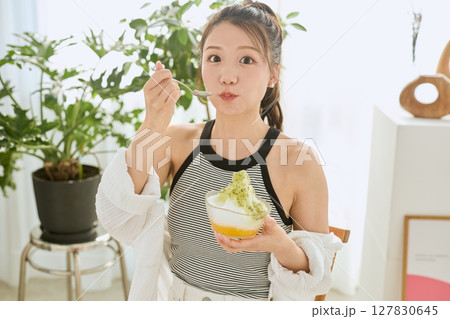 かき氷を食べて夏を楽しむ笑顔の若い女性のライフスタイル 127830645