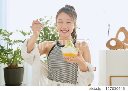 かき氷を食べて夏を楽しむ笑顔の若い女性のライフスタイル 127830646