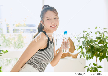 部屋ででラムネを楽しむ夏の爽やかな若い女性の笑顔 127830660