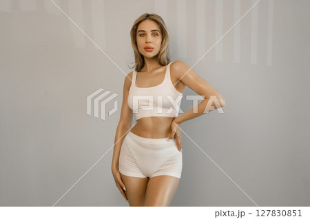Perfect shape of belly, hips. Beautiful body of young slim woman in white underwear isolated on gray studio background. Wellness, weight loss, treatment, healthcare, fitness concept. Flyer 127830851