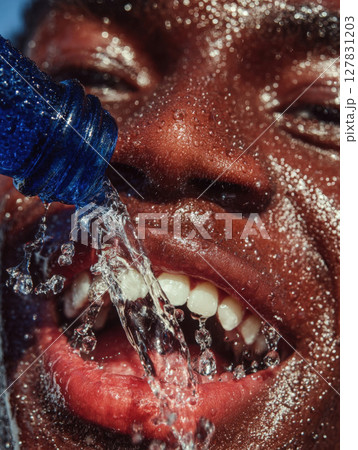 Refreshing Burst Hydration in Action A Close Up of a Man Face as Cool Water Splashes Over Him from a Vibrant Blue Bottle, Capturing the Essence of Thirst Quenching and Revitalization 127831203