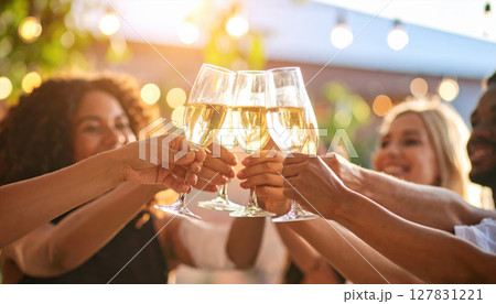 Young people raising glasses in celebration at joyful party 127831221