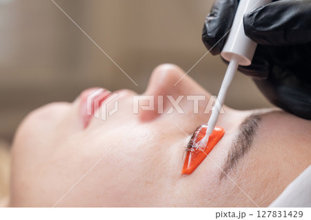 Caucasian woman undergoing eyelash lamination procedure. Caucasian woman undergoing eyelash lamination procedure. 127831429
