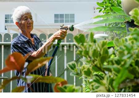Senior asian woman watering the garden 127831454