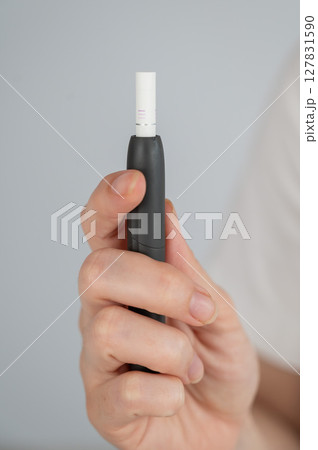 Faceless woman holding tobacco heating system.  127831590