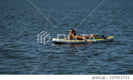 Caucasian woman posing on a SUP board. Summer sport. 127831721