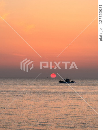 夕日に向かう漁船と海のシルエット 127833081