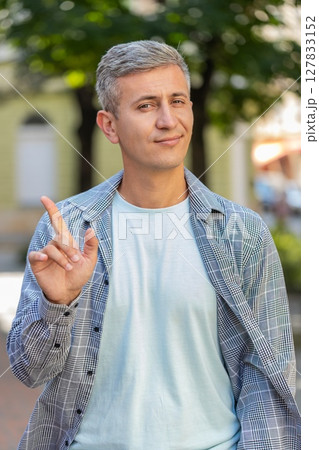 Upset man reacting to unpleasant awful idea, wave hand, shake head No while standing on city street 127833152