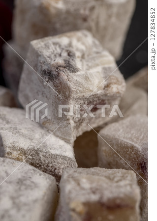 Turkish delight with cherry on a slate close up, cubes of sweet Turkish delight with the addition of dried red berries in powdered sugar Turkish delight with cherry on a slate close up, cubes of sweet Turkish delight with the addition of dried red berries in powdered sugar 127834852