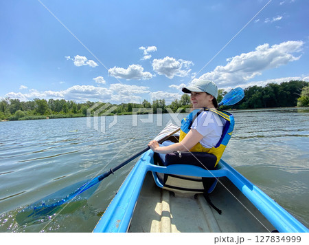 Female Kayaker Enjoying Nature. Scenic Water Journey. Female Kayaker Enjoying Nature. Scenic Water Journey. 127834999