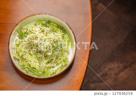 Fresh shredded cabbage salad with sunflower seeds and dill served with green herb dressing for a light and nutritious meal option Fresh shredded cabbage salad with sunflower seeds and dill served with green herb dressing for a light and nutritious meal option 127836259
