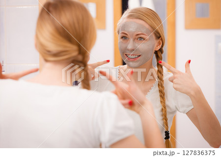 Woman with grey clay mud mask on her face Woman with grey clay mud mask on her face 127836375