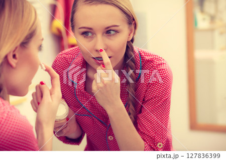 Woman applying moisturizing skin cream. Skincare. 127836399