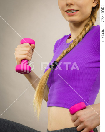 Woman working out at home with dumbbell 127836500