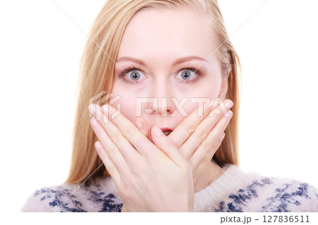 Shocked young woman covering mouth with hand Shocked young woman covering mouth with hand 127836511