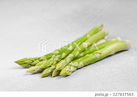 Pile of fresh raw green asparagus or sparrowgrass stems on light textured background 127837563