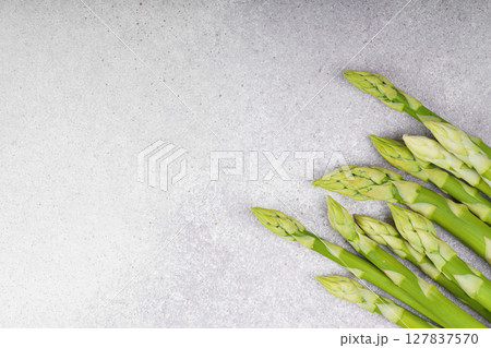 Pile of fresh green asparagus or sparrowgrass stems macro, close up on light textured background Pile of fresh green asparagus or sparrowgrass stems macro, close up on light textured background 127837570