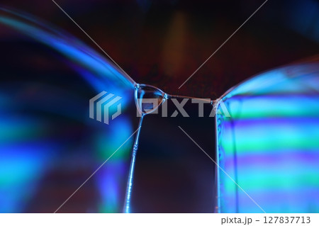 Bright blue liquid surface on black background, oil stains movement, bright chemistry, surreal background, blue sky colour, connection lines, water waves 127837713