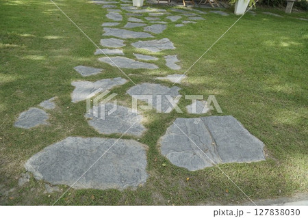 Path made of stones is in a grassy area 127838030