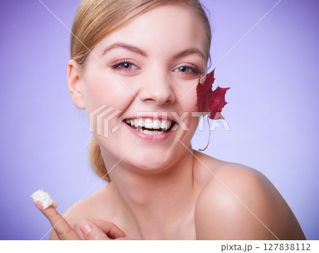 Skin care. Face of young woman girl with red maple leaf. 127838112