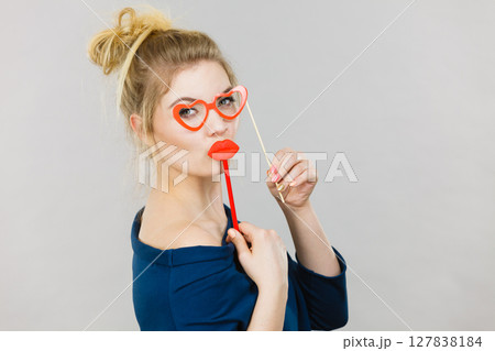 woman holds carnival accessories on stick 127838184