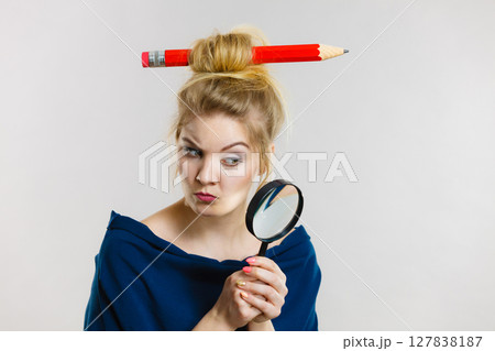 Woman holding magnifying glass having hair pencil 127838187