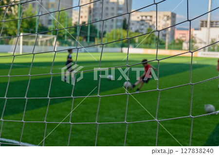 Children enjoy kicking a soccer ball on a grassy field. High quality photo 127838240