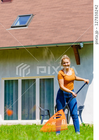 Woman with rake in garden 127838242