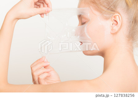 girl removing facial peel off mask girl removing facial peel off mask 127838256
