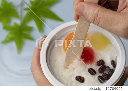 水辺でかき氷を木のスプーンで食べる 水辺でかき氷を木のスプーンで食べる 127840024