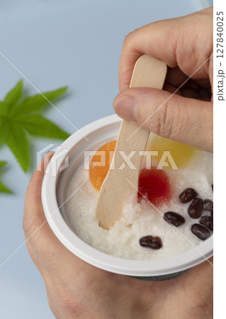 水辺でかき氷を木のスプーンで食べる 水辺でかき氷を木のスプーンで食べる 127840025