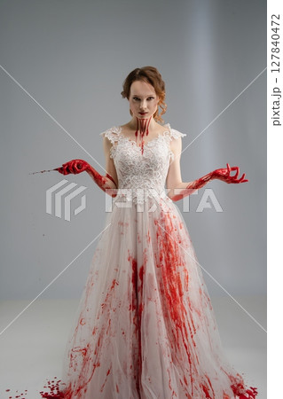 Bride in bloodstained gown wields katana evoking a dark princess theme 127840472