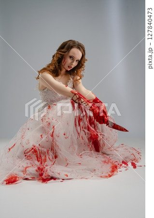 Bride in bloodstained lingerie holds katana in a hauntingly beautiful portrayal Bride in bloodstained lingerie holds katana in a hauntingly beautiful portrayal 127840473
