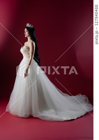 Graceful bride in luxurious lingerie inspired gown against a vibrant backdrop 127840488