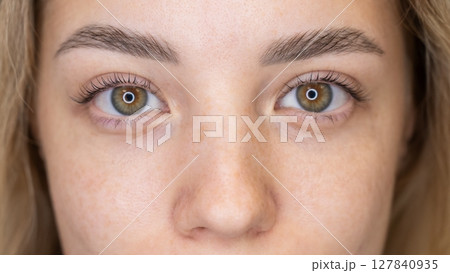 Close-up portrait of a woman after eyelash lamination procedure.  127840935