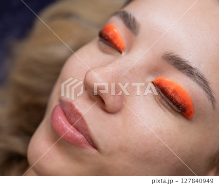 Caucasian woman undergoing eyelash lamination procedure.  127840949