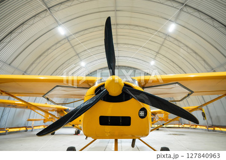 Yellow airplane glider in the hangar.  127840963