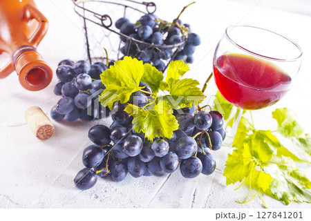 Red wine grapes on white table 127841201