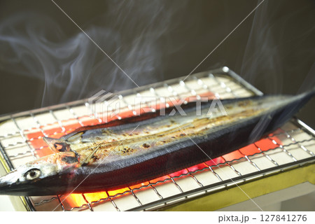 煙り立ち昇る七輪でサンマの開きを焼く 127841276